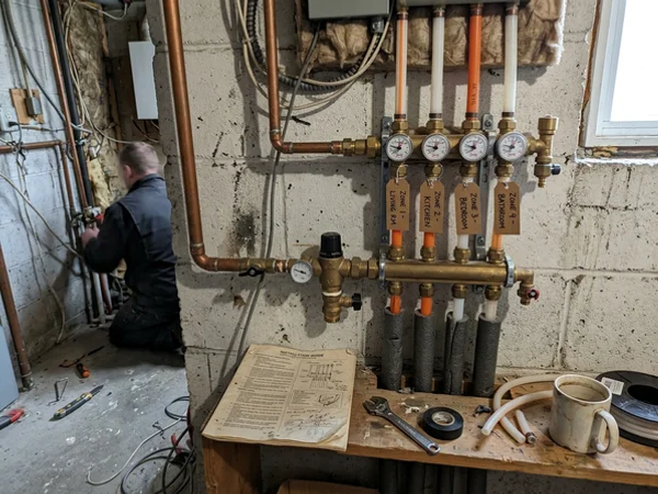 Radiant manifold with four labelled zone loops, flow meters and a mixing valve