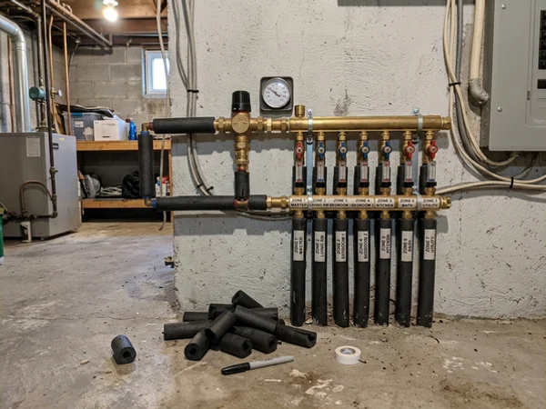 Thermostatic mixing valve and zone manifold serving a radiant zone